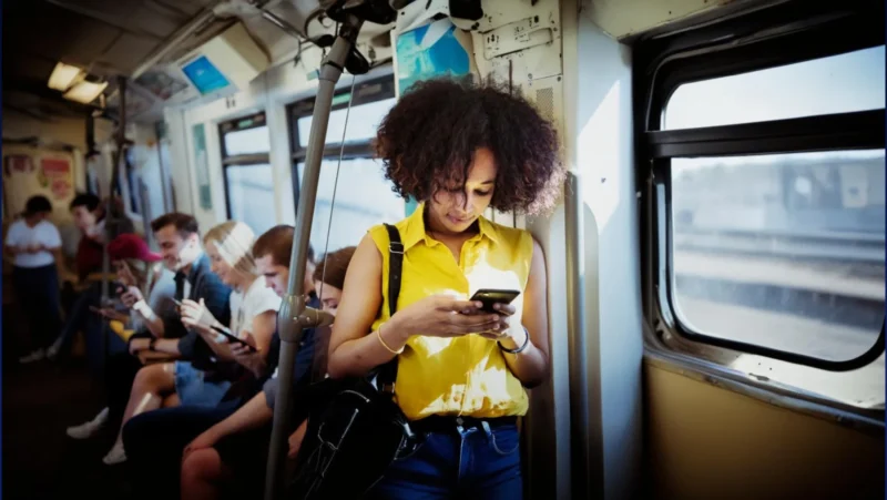 Passeggeri con smartphone su autobus, monitoraggio AI via WiFi.