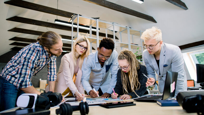 Team di studenti e professionisti lavora a un progetto AI collaborativo.